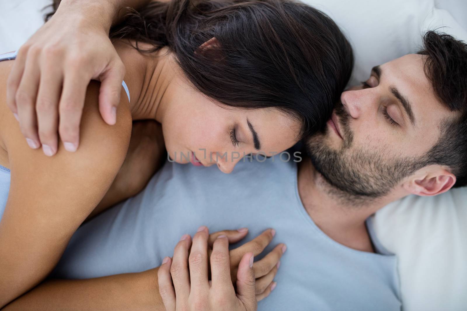 Young romantic couple sleeping on bedÂ in bedroom