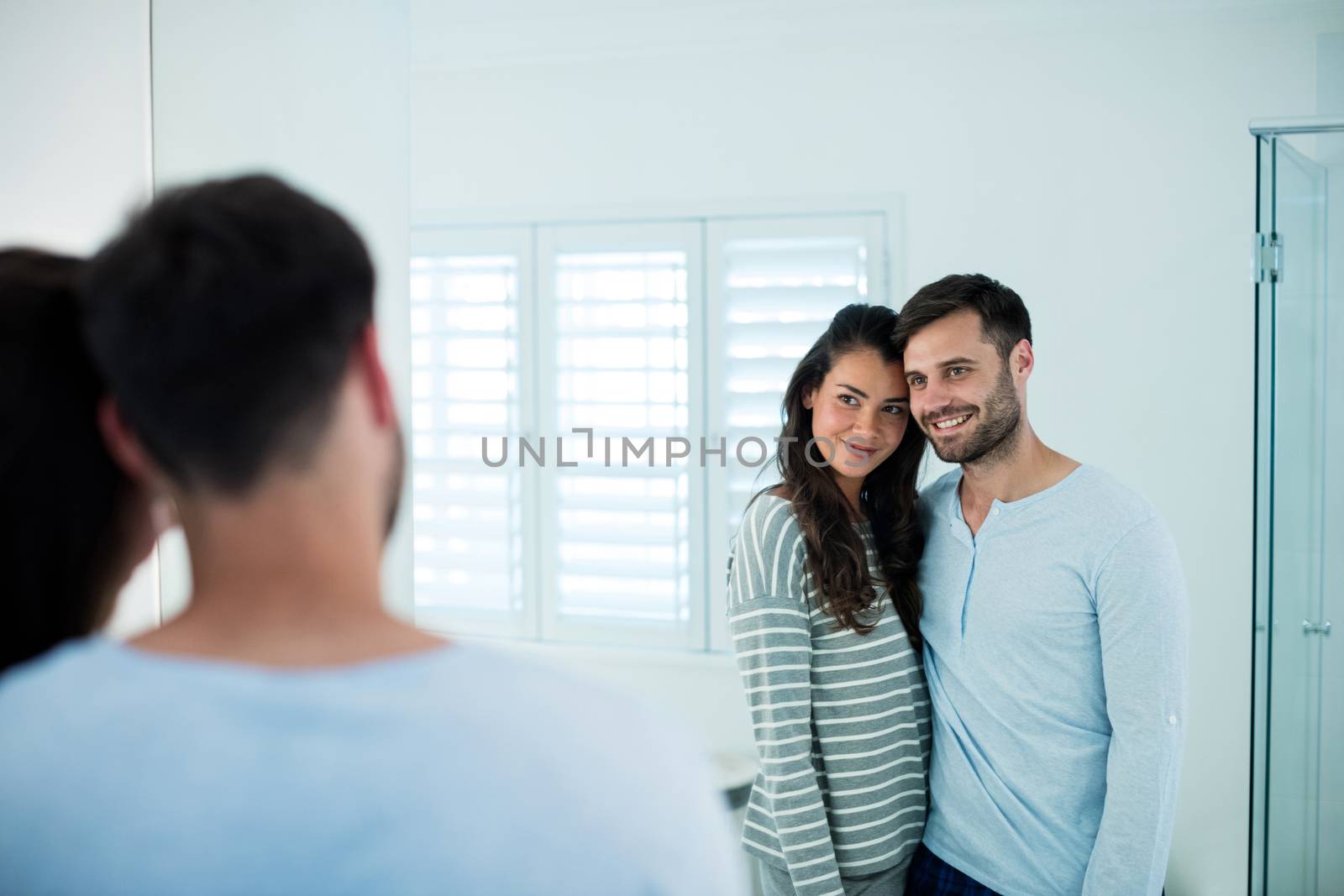 Couple looking in bathroom mirror together by Wavebreakmedia