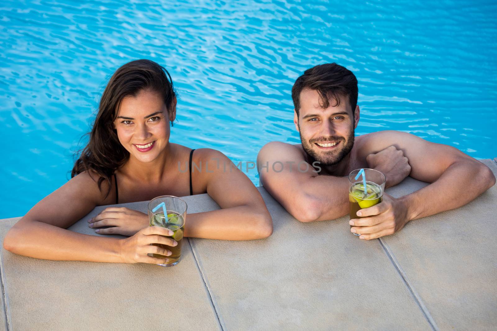 Portrait of young romantic couple relaxing in the pool