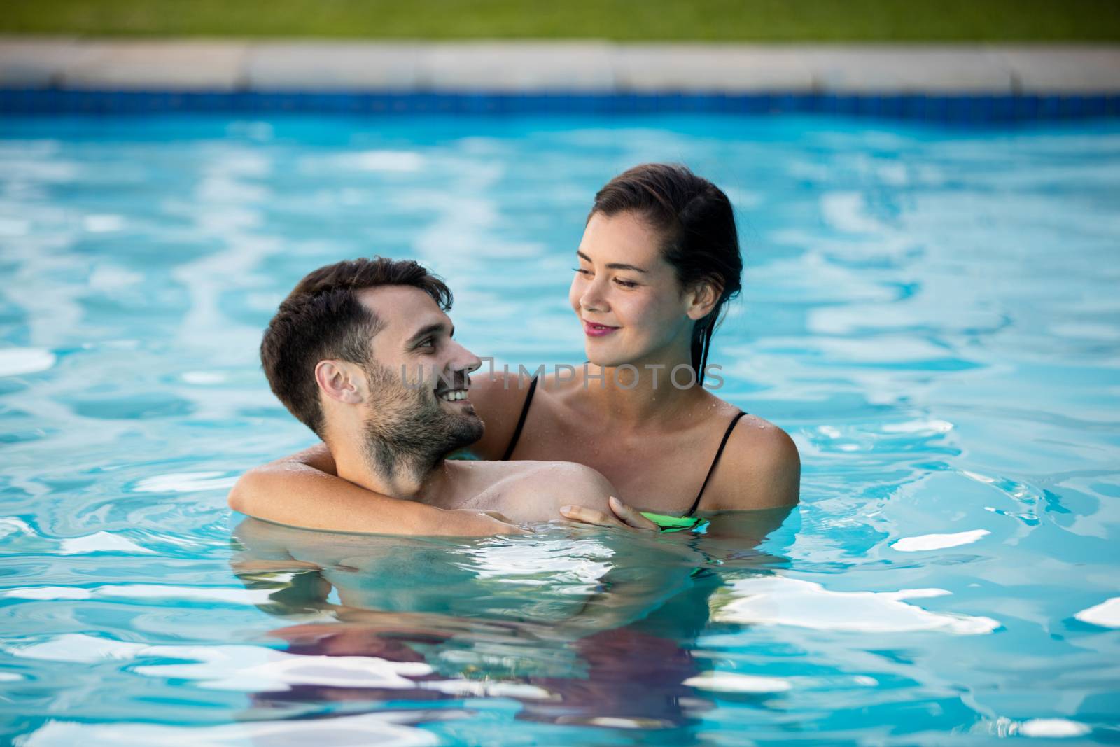 Young couple embracing each other in the pool by Wavebreakmedia