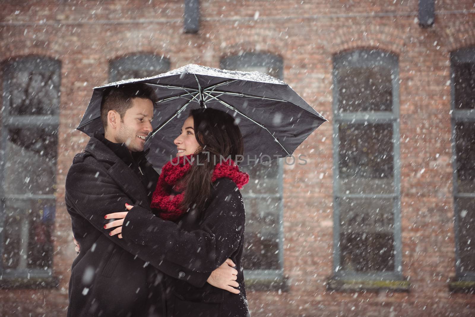 Romantic couple embracing during snowfall
