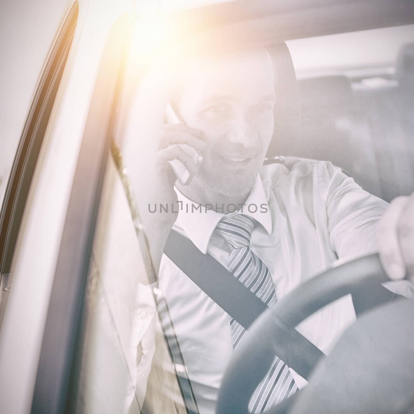 Man driving a car and using his phone