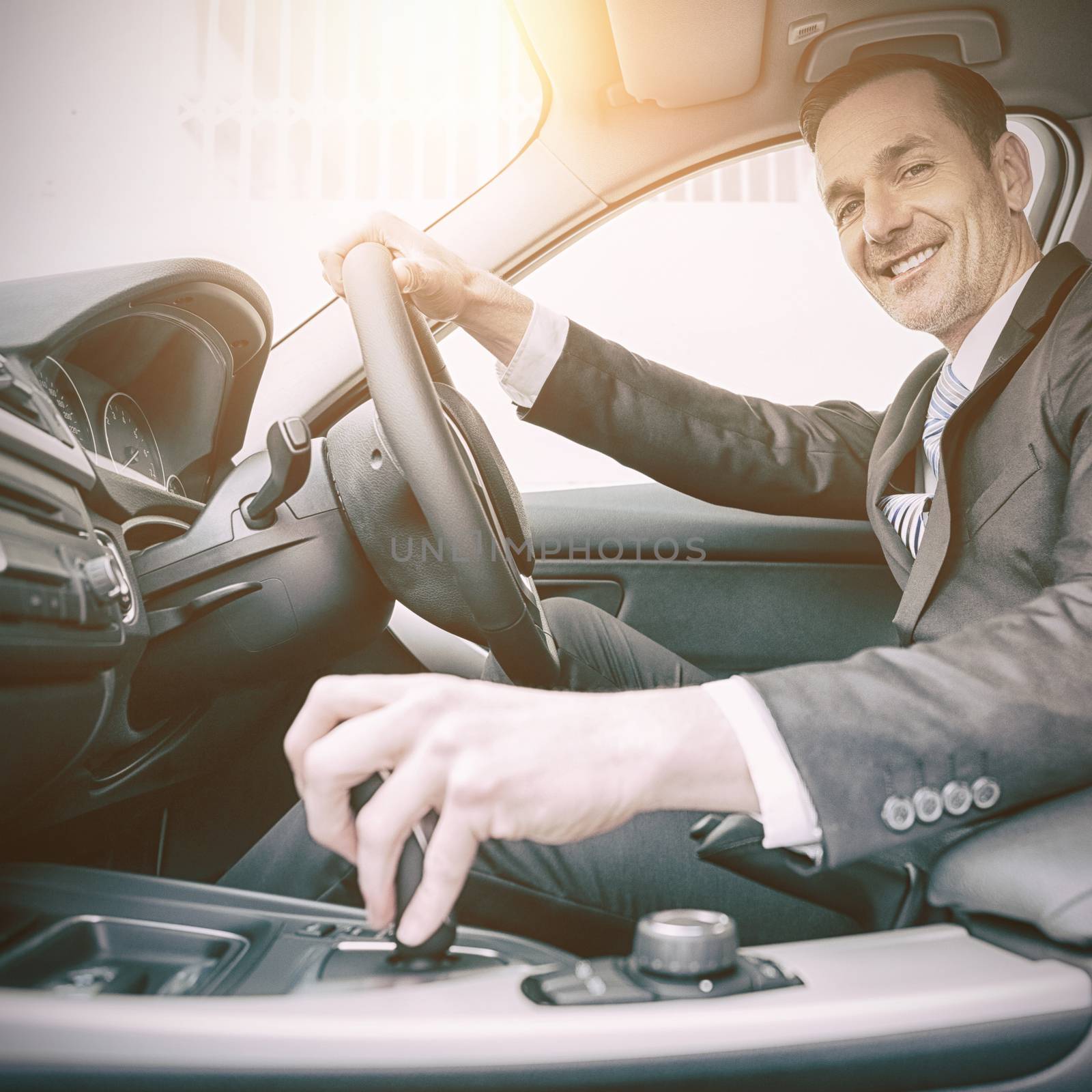 Man driving a car and smiling at camera