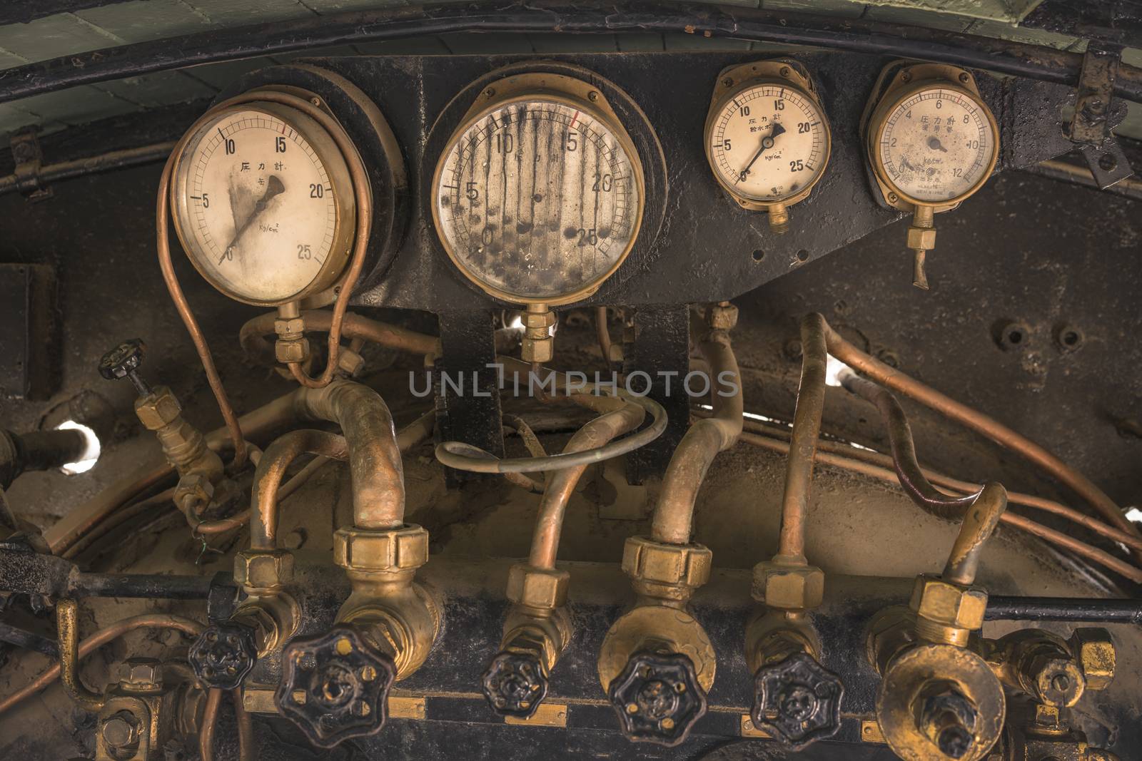 Golden and black Pressure gauge and Feed water pump valves of an old steam engine in Asukayama Park in the Kita District of Tokyo, Japan.