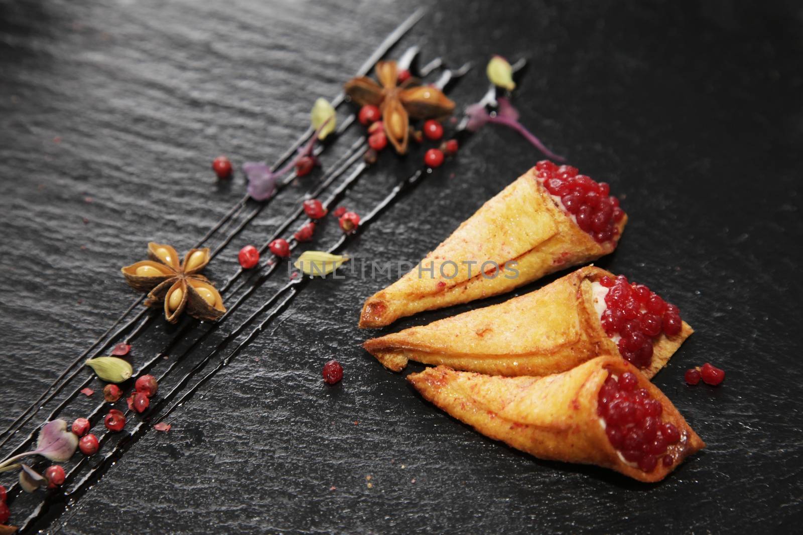 Rabbit pate in crispy horns decorated with spices on a black stone plate