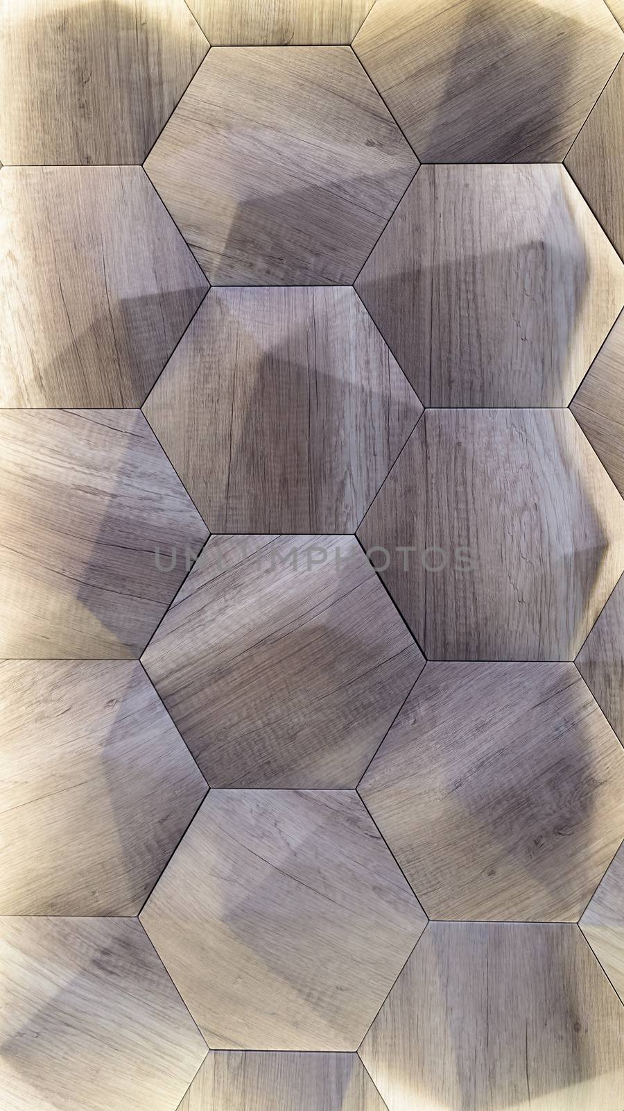 3D decorative wall with imitation wood texture for the interior of an unusual hexagonal geometric shape similar to honeycombs. Gray-brown light background with a pattern imitating a tree. Abstract texture