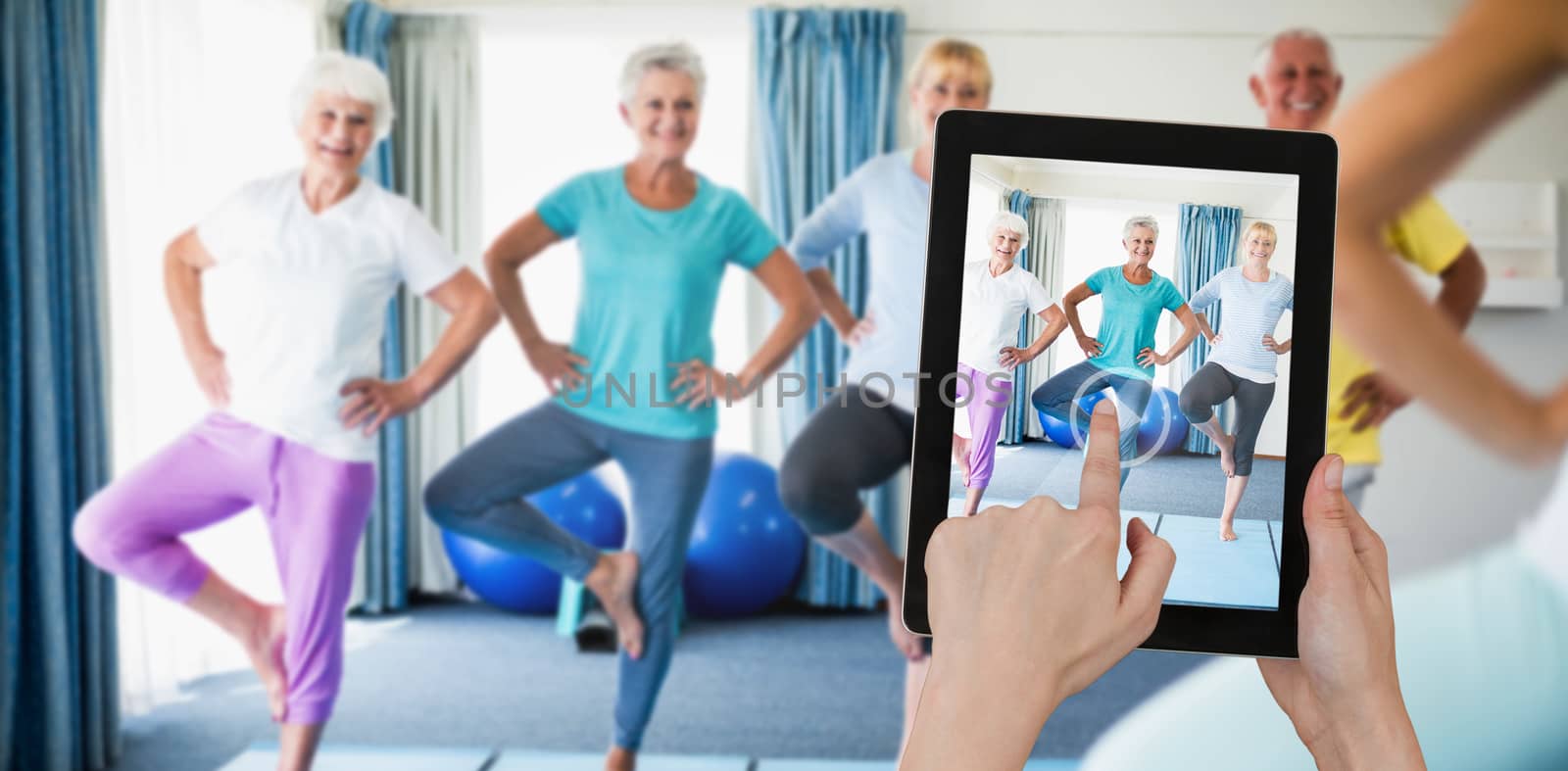 Hands touching digital tablet against white background against instructor performing yoga with seniors