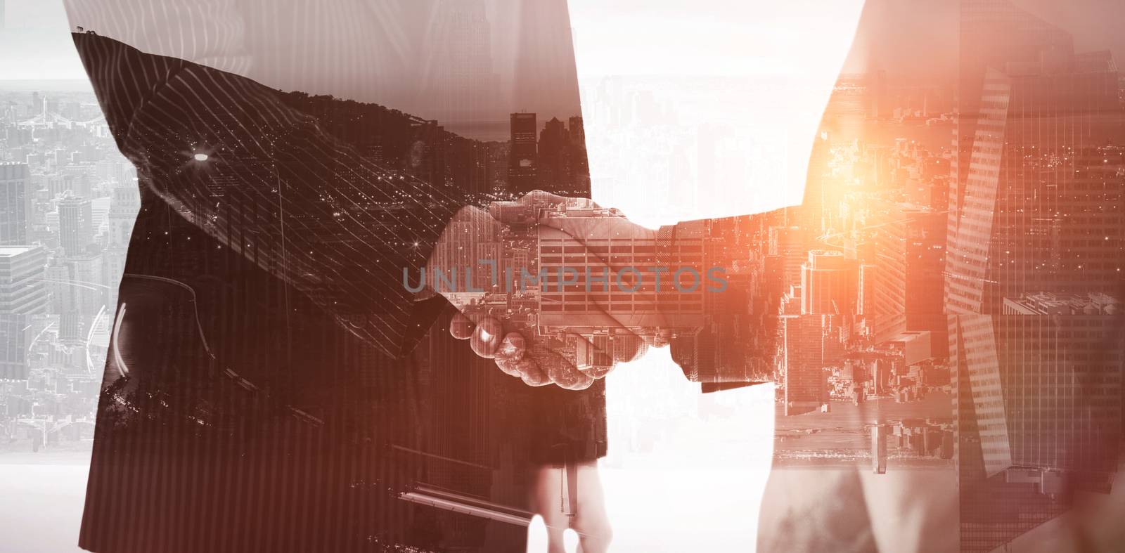 View of the city by night against composite image of business people shaking hands