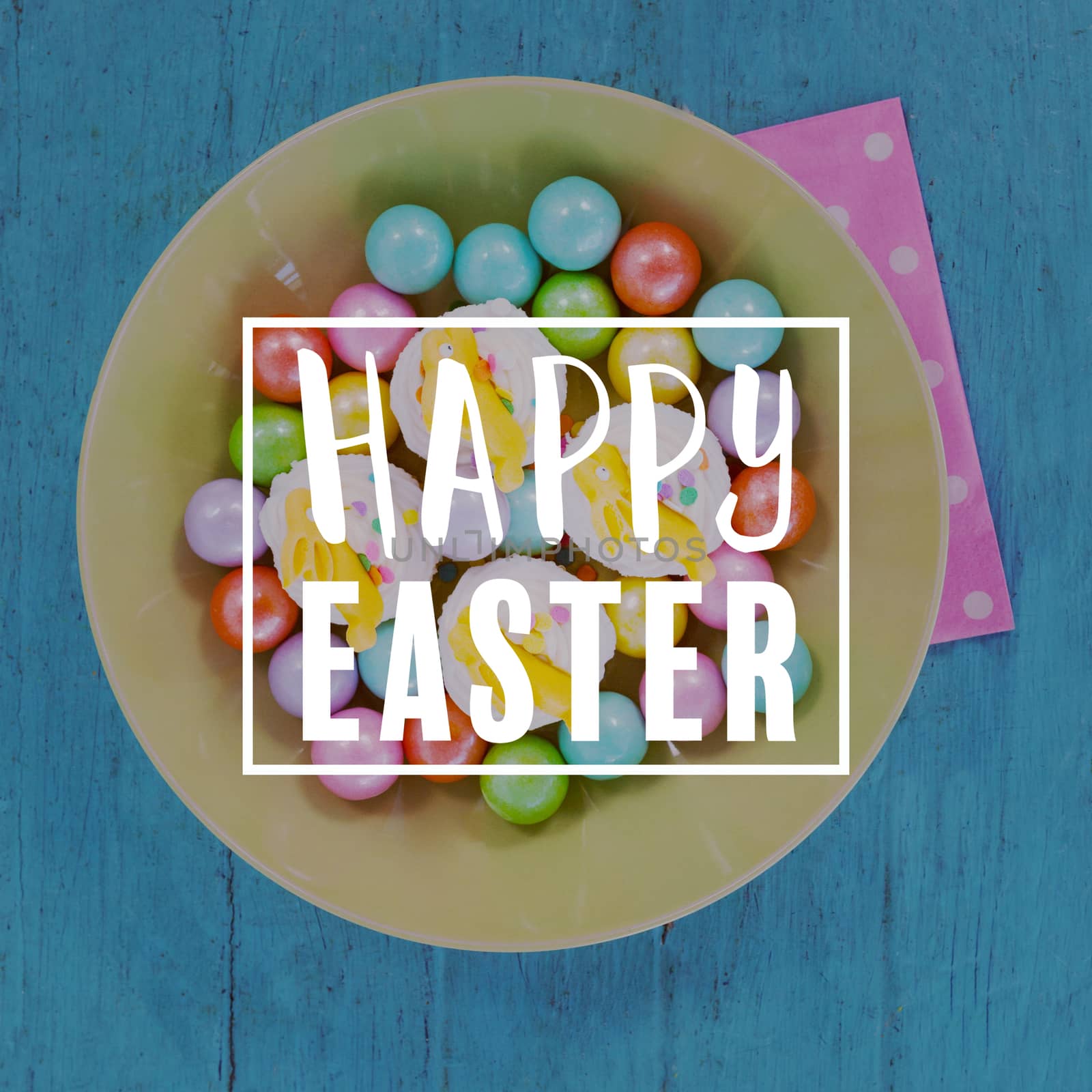 Easter greeting against colorful chocolates and cupcakes in bowl