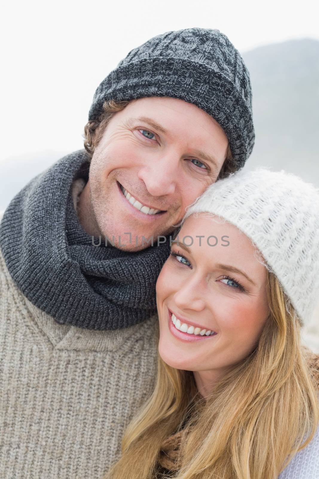 Closeup portrait of a romantic young couple in warm clothing outdoors