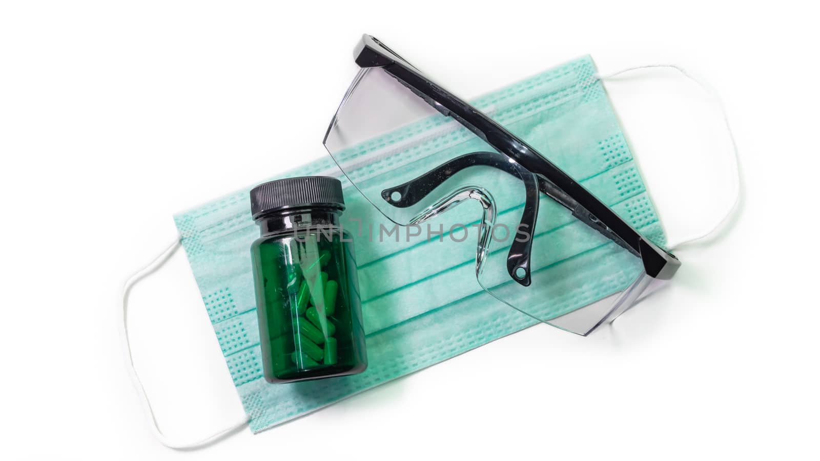 The close up of Anti-viral protection mask and Eye protection glasses and Medicine bottle on white background.
