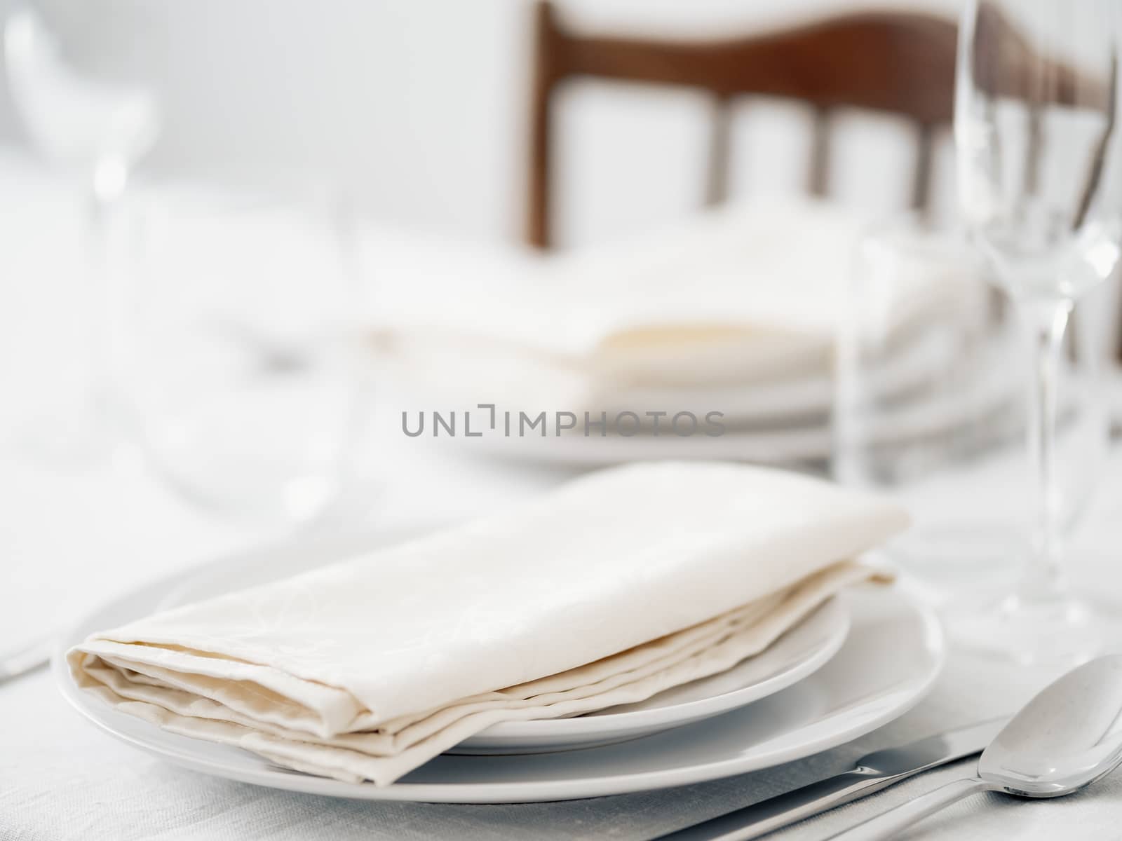 Beautiful table setting in white colors. Empty white plates. Set table for romantic dinner for two at home