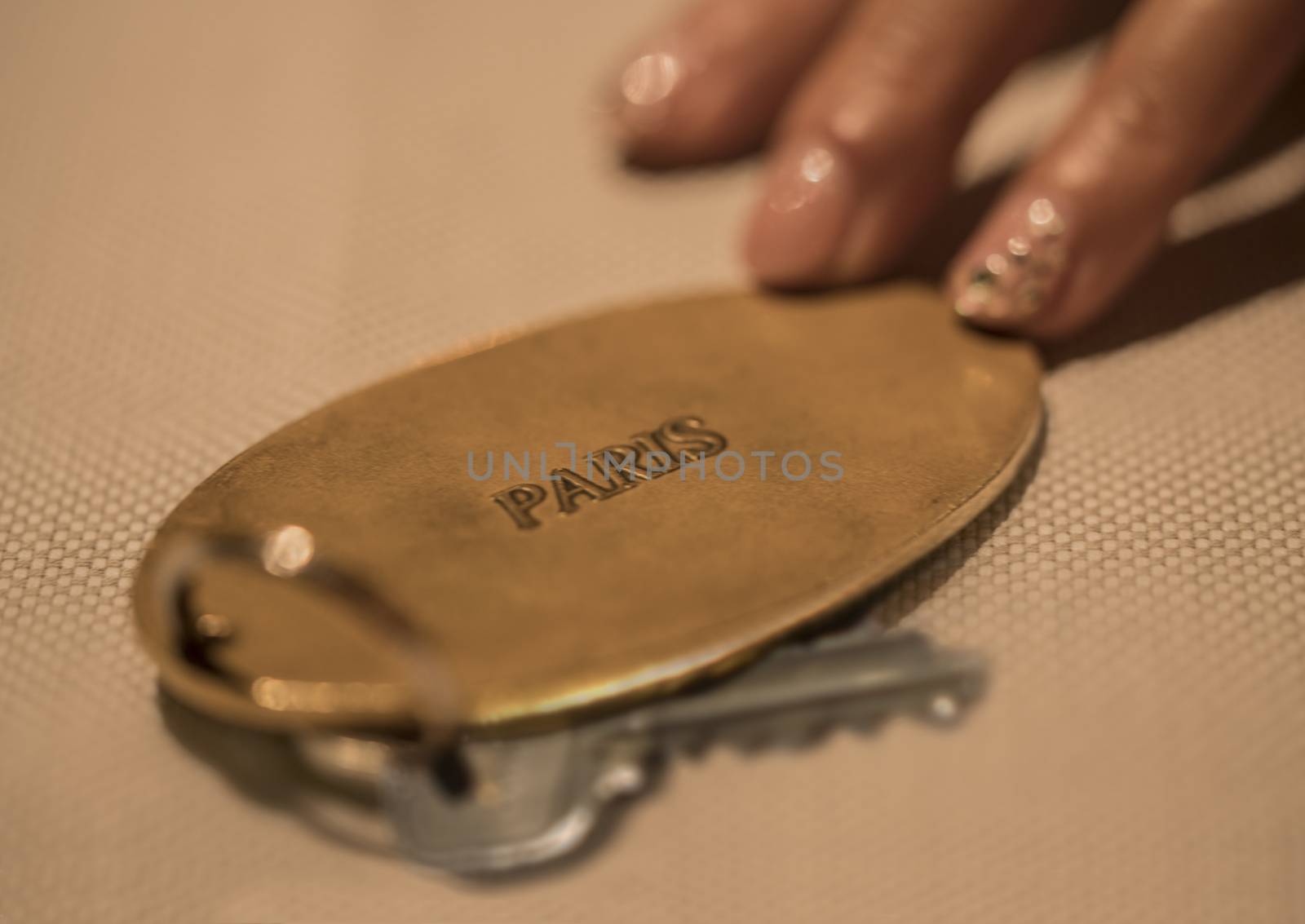 Hand of woman with key of luxury hotel room in France in Paris