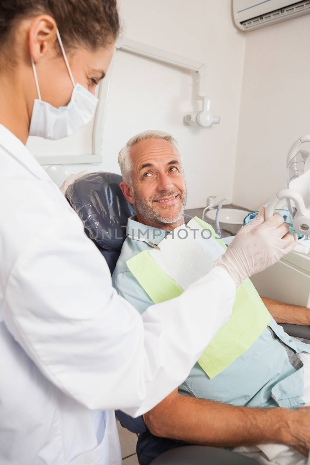 Patient smiling at dentist in the chair by Wavebreakmedia