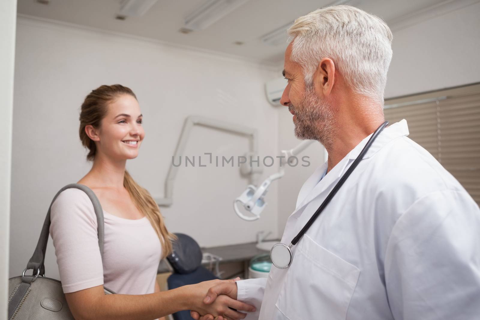 Dentist shaking hands with his patient by Wavebreakmedia