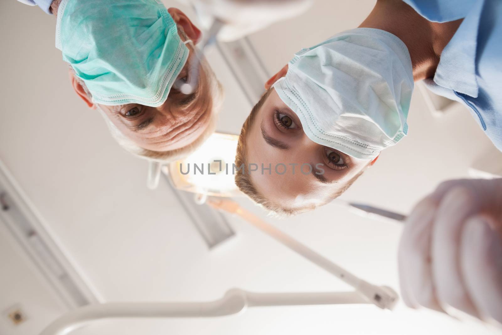 Dentist and assistant leaning over patient by Wavebreakmedia