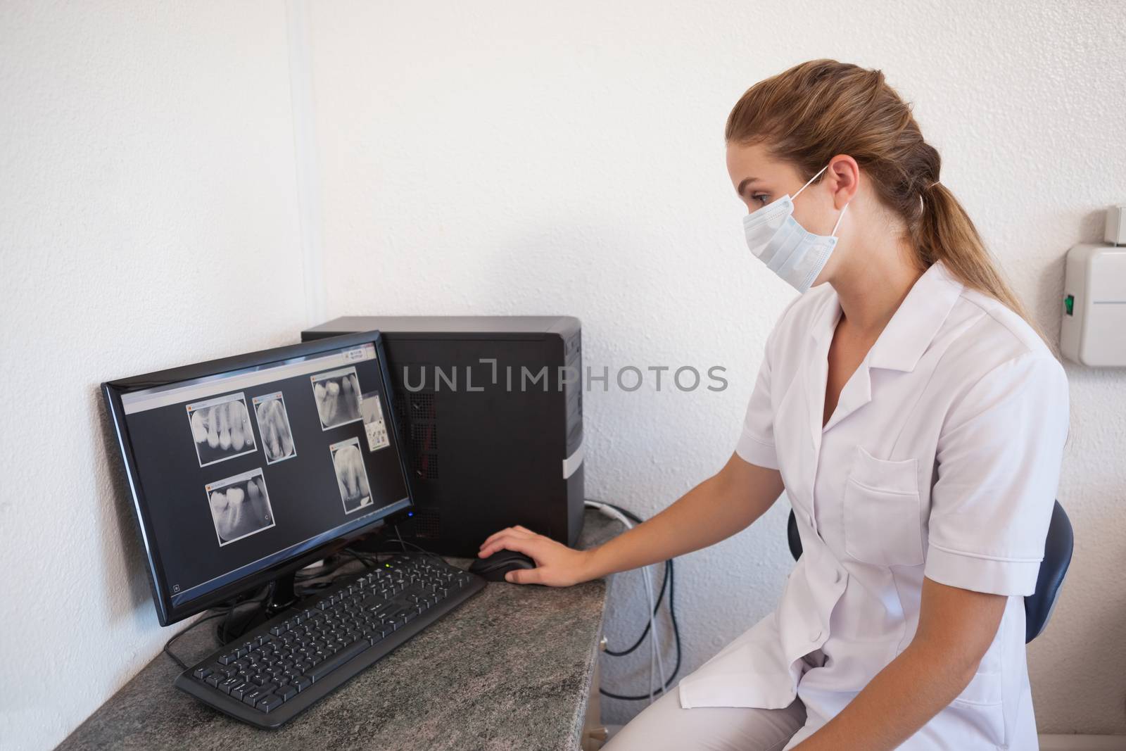 Dental assistant looking at x-rays on computer by Wavebreakmedia
