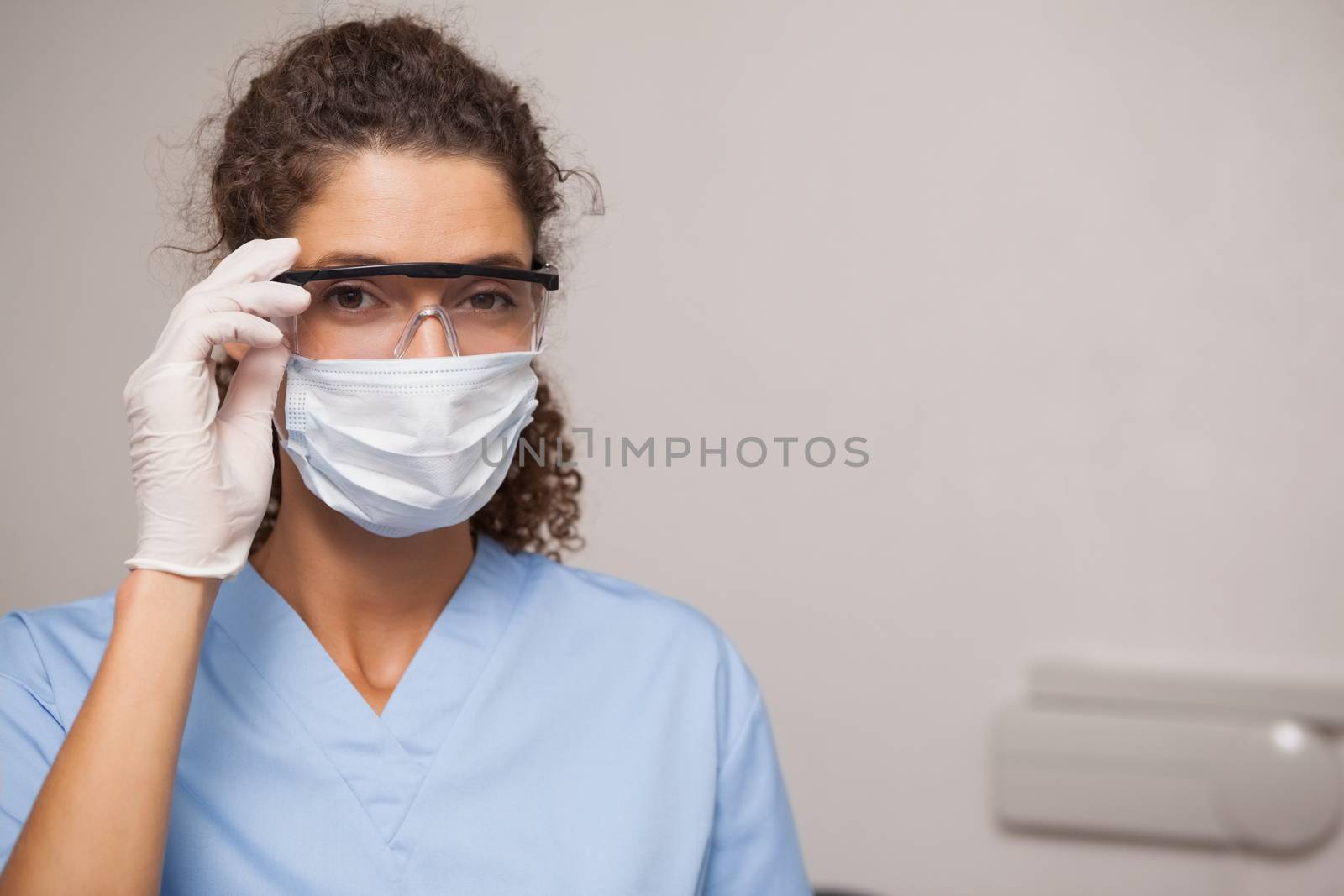 Dentist in surgical mask and protective glasses by Wavebreakmedia