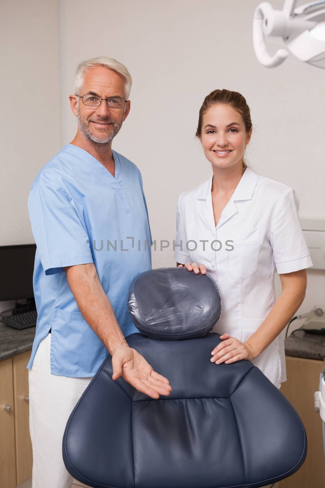 Dentist and assistant smiling at camera inviting you to the chair by Wavebreakmedia