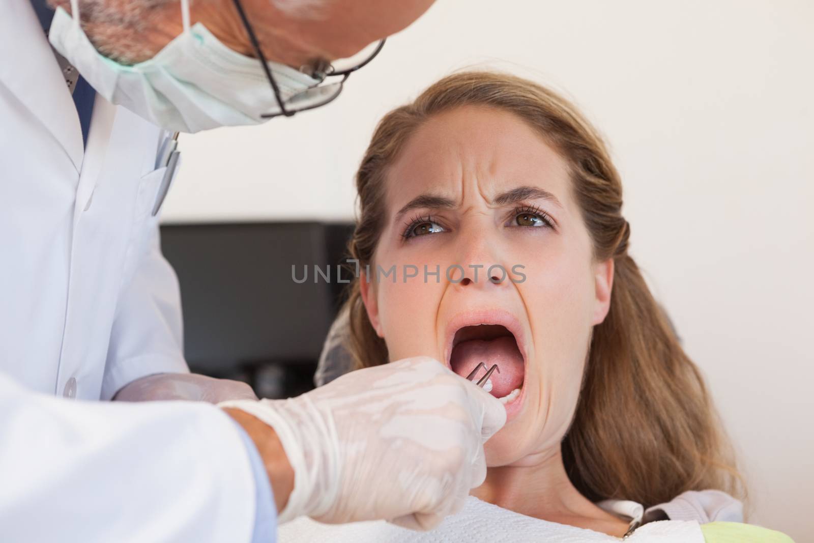Dentist about to pull a terrified patients tooth by Wavebreakmedia