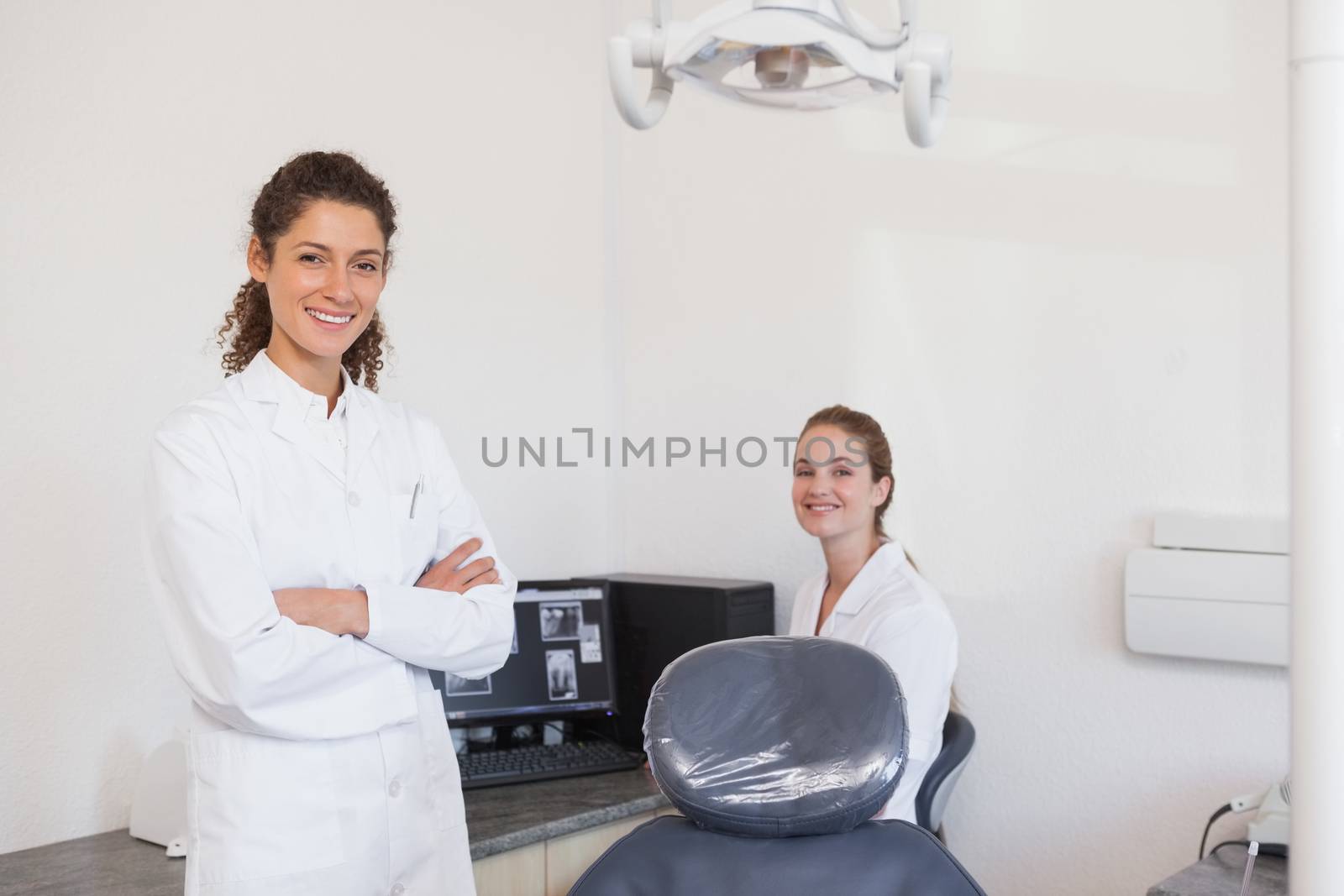 Dentist and assistant smiling at camera by Wavebreakmedia
