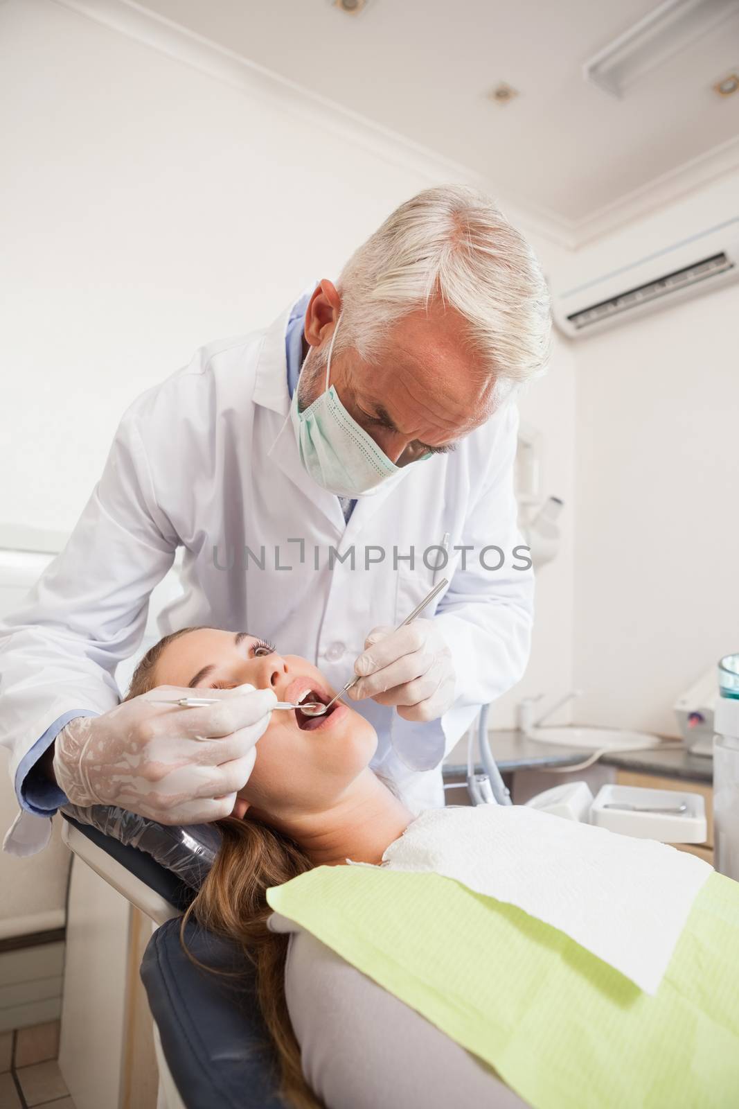 Dentist examining a patients teeth in the dentists chair by Wavebreakmedia