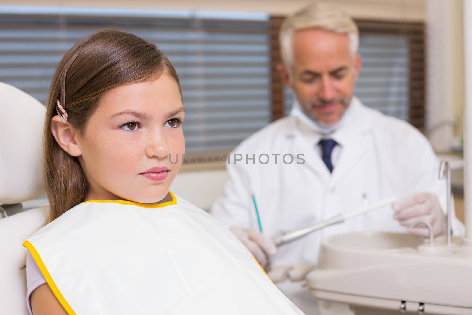 Pediatric dentist and little girl sitting in chair by Wavebreakmedia