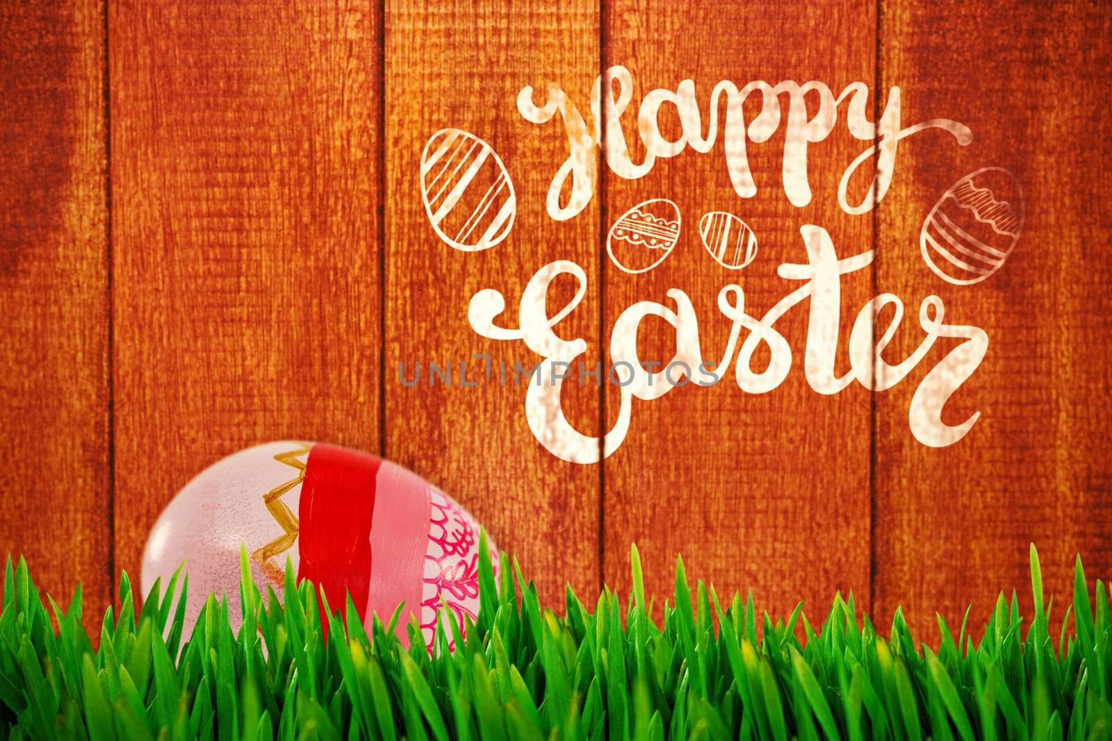 Grass growing outdoors against painted easter eggs on white background