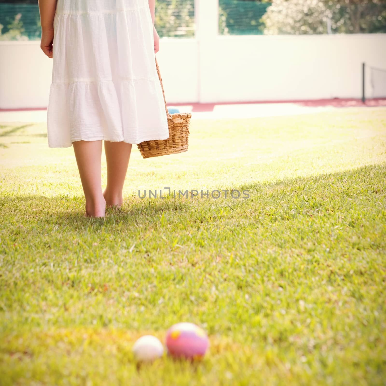 Little girl collecting easter eggs outside in the garden