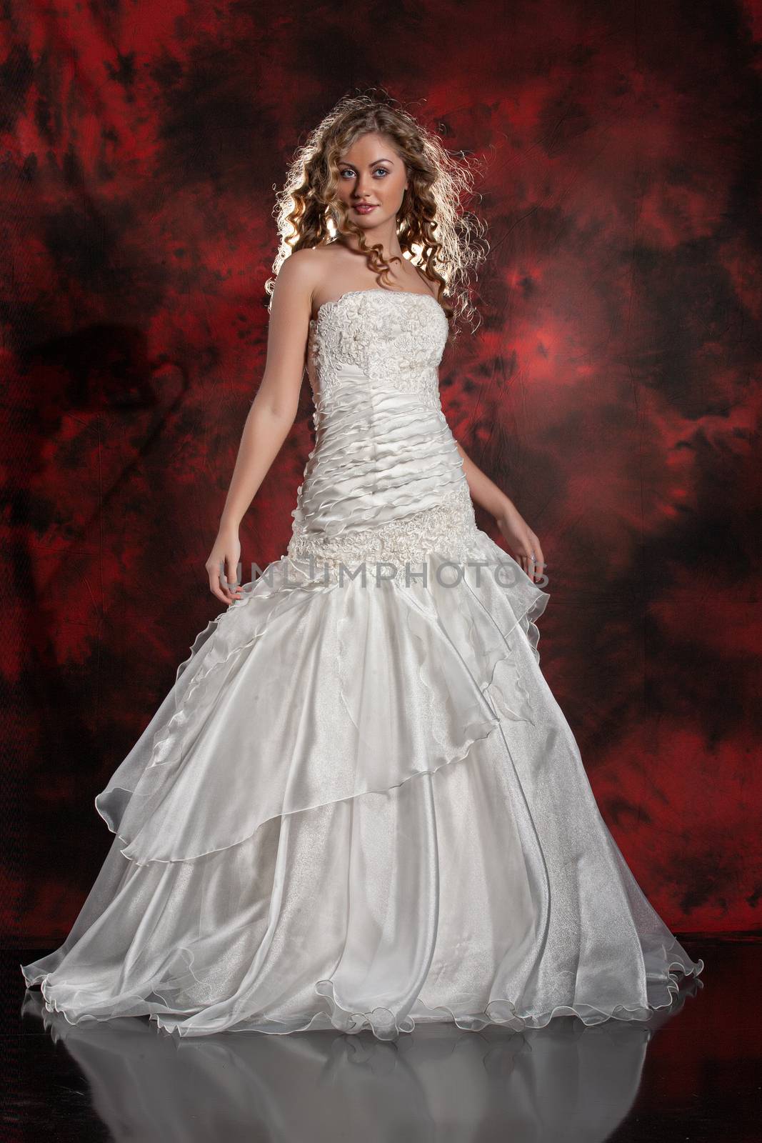 Young beautiful woman in a wedding dress on a studio background