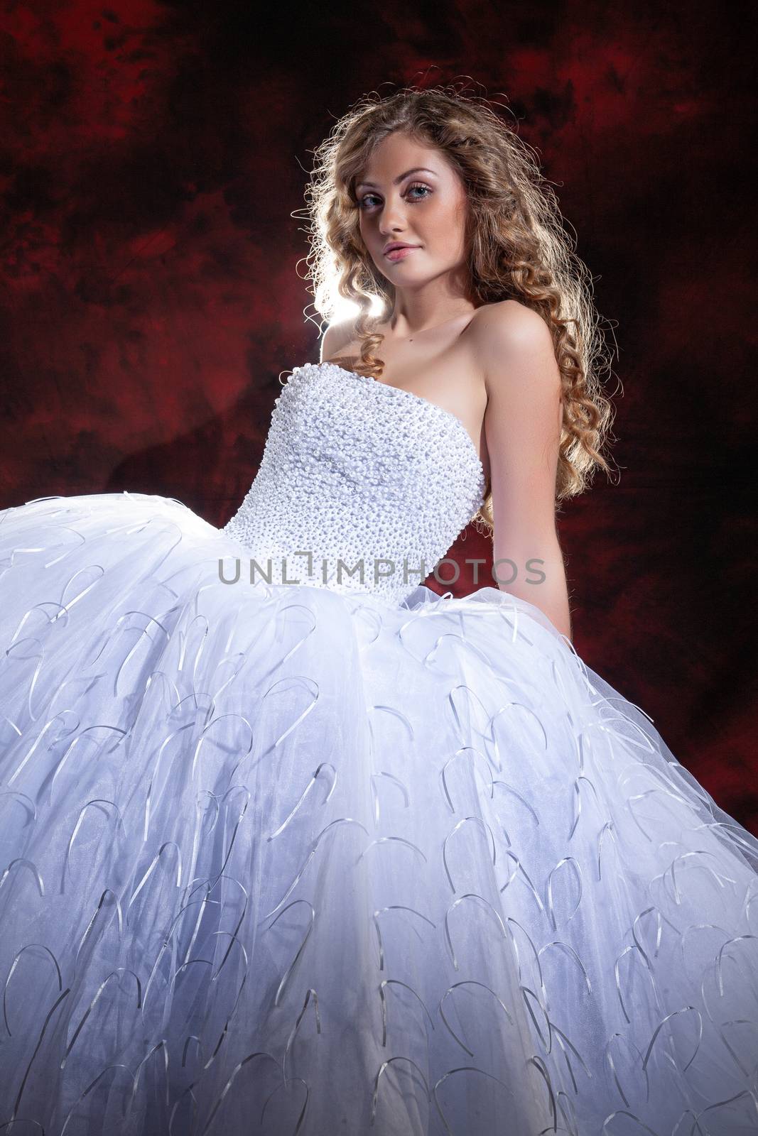 Young beautiful woman in a wedding dress on a studio background