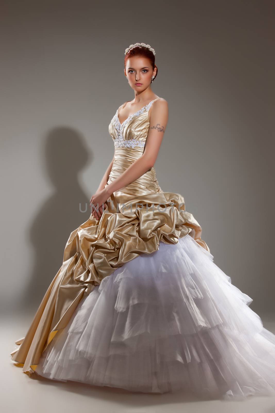 Young beautiful woman in a wedding dress on a studio background