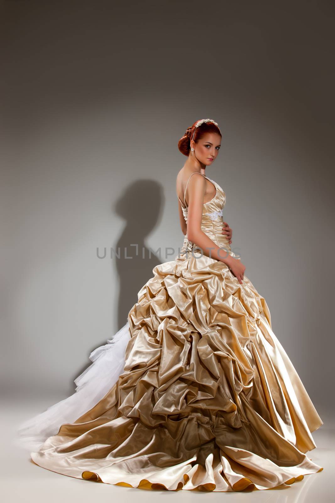 Young beautiful woman in a wedding dress on a studio background