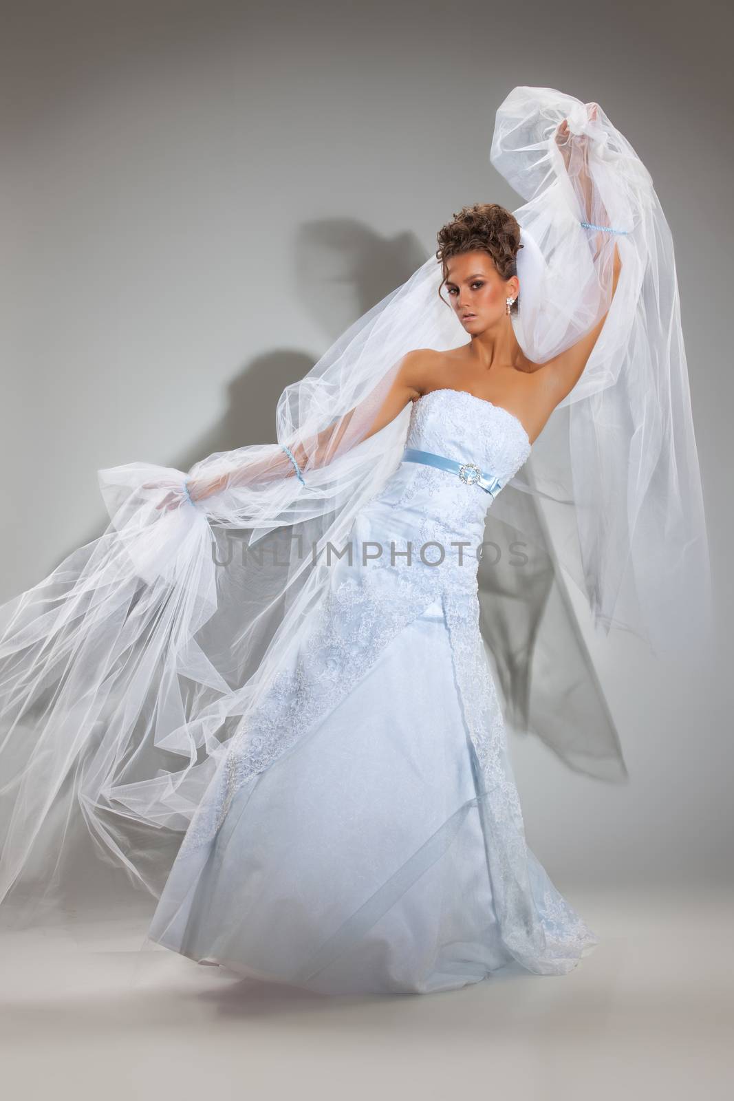 Young beautiful woman in a wedding dress on a studio background