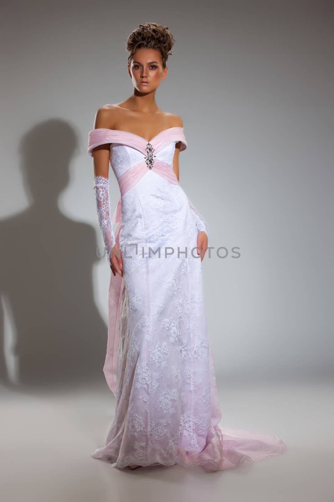 Young beautiful woman in a wedding dress on a studio background