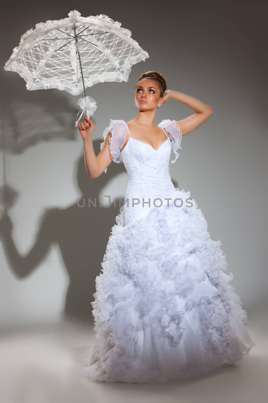 Young beautiful woman in a wedding dress on a studio background