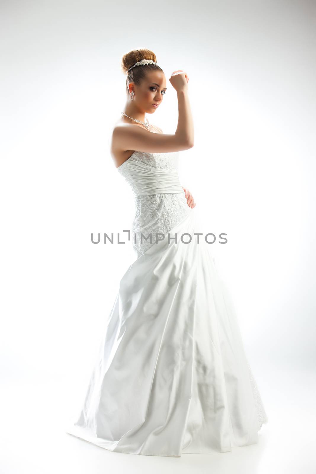 Young beautiful woman in a wedding dress on a studio background