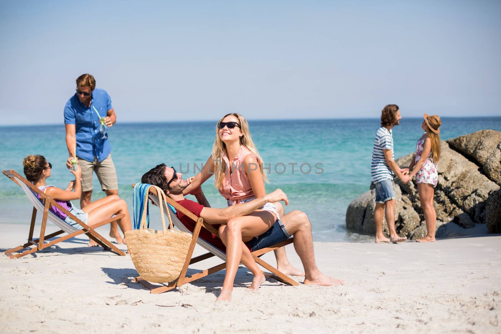 Romantic couples on shore at beach during sunny day