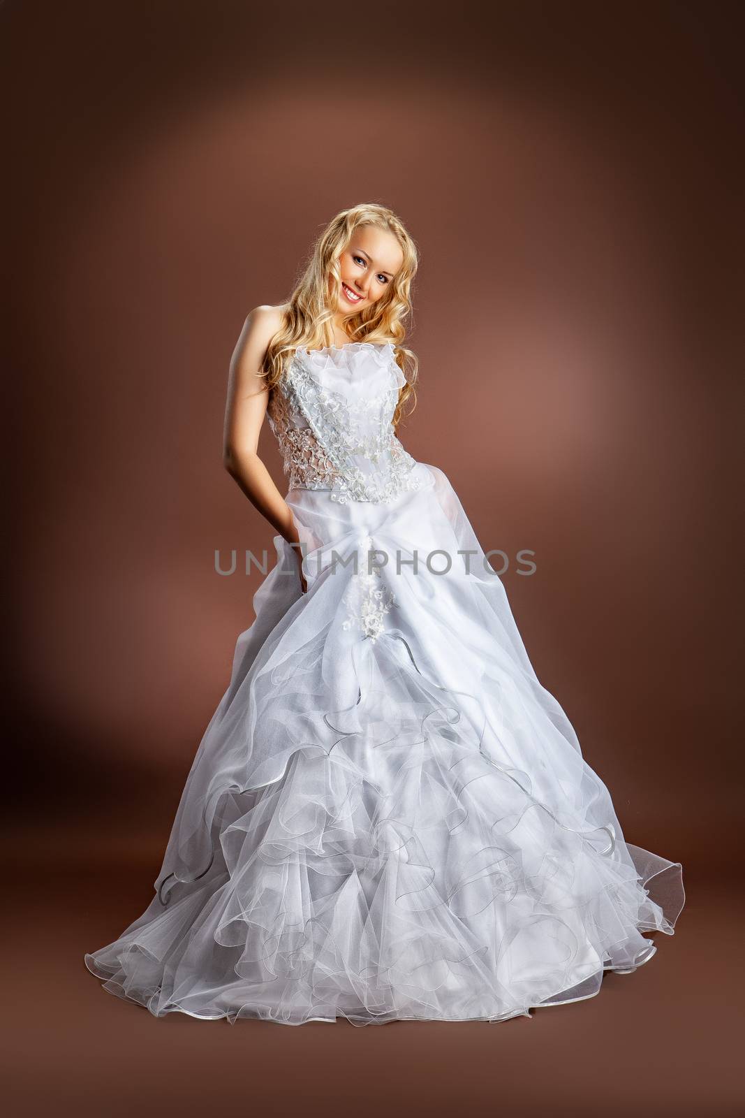 Young beautiful woman in a wedding dress on a studio background