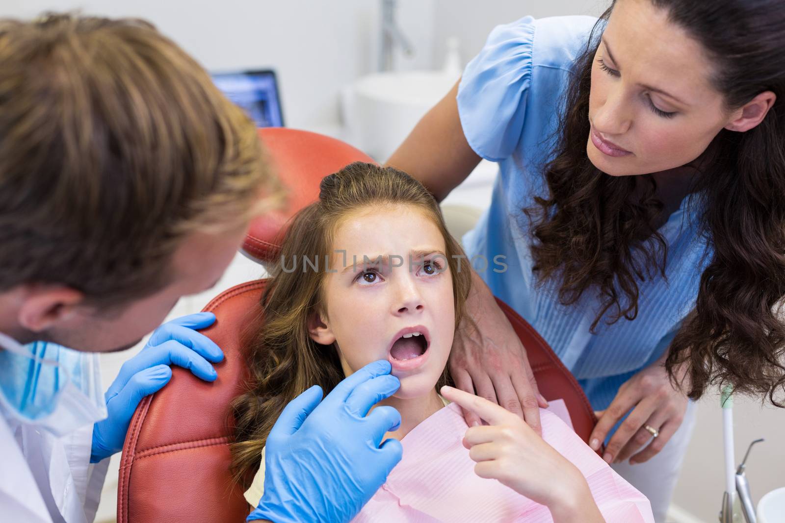 Dentist examining young patient at dental clinic