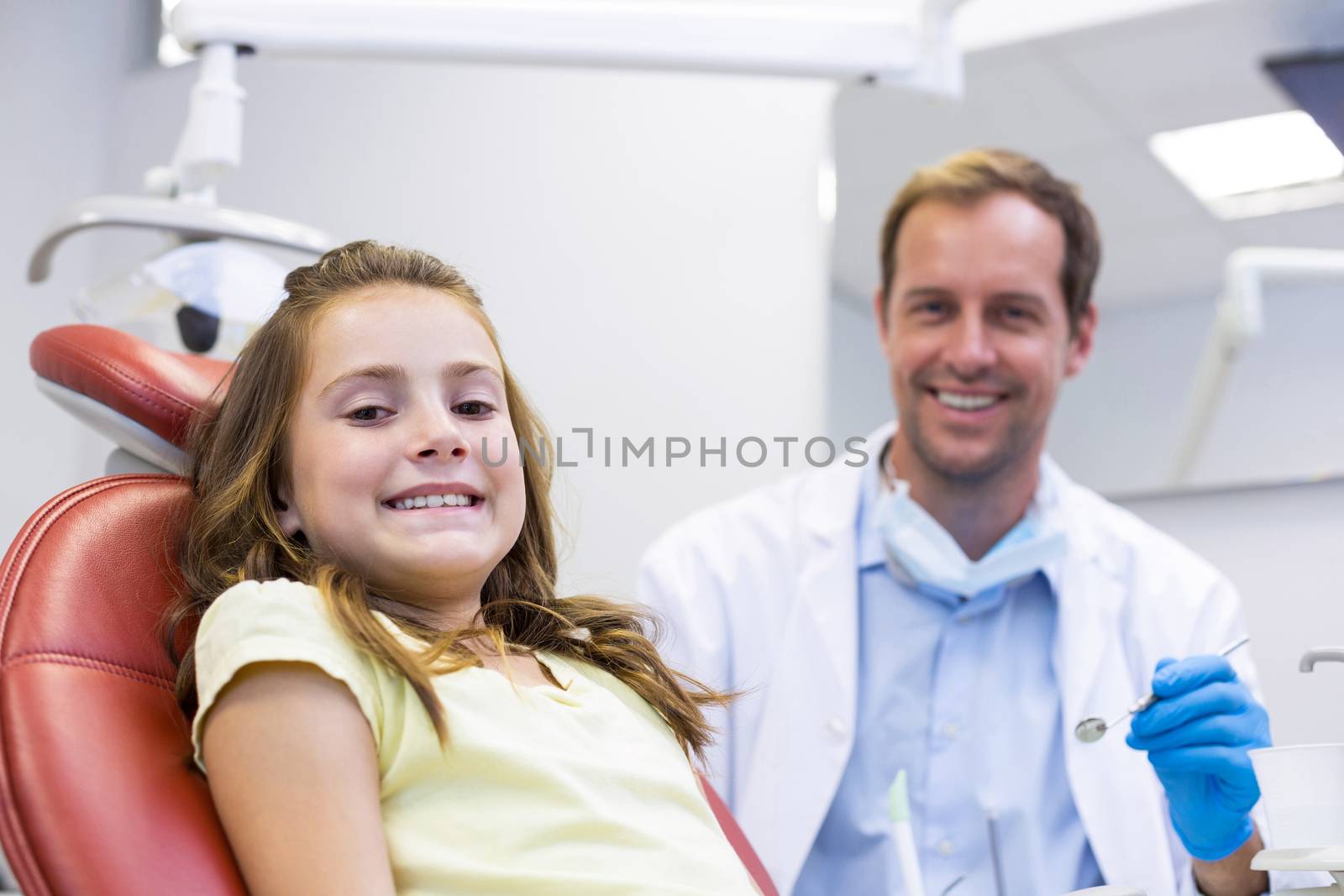 Portrait of smiling dentist and young patient by Wavebreakmedia