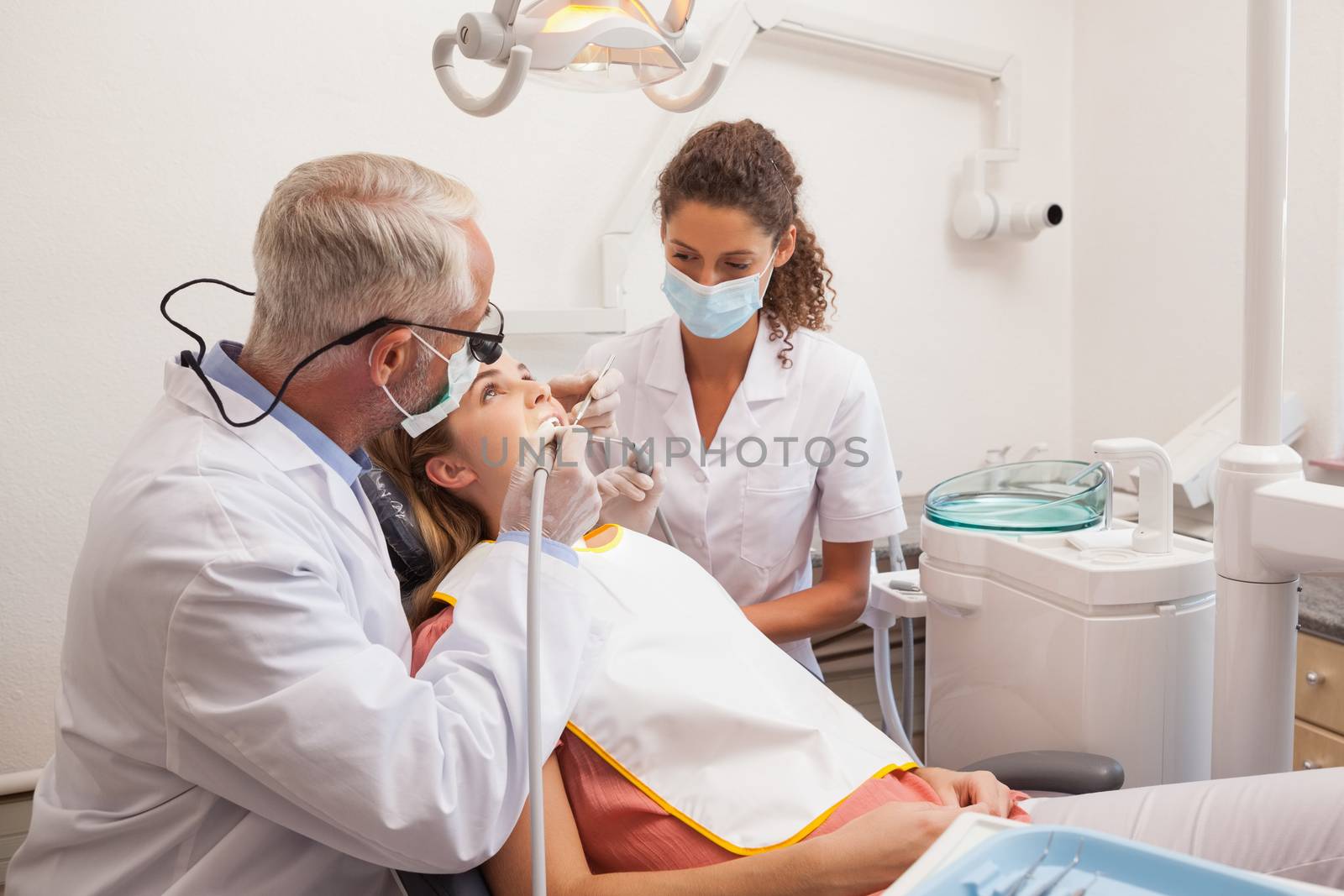 Dentist and assistant examining patients teeth by Wavebreakmedia