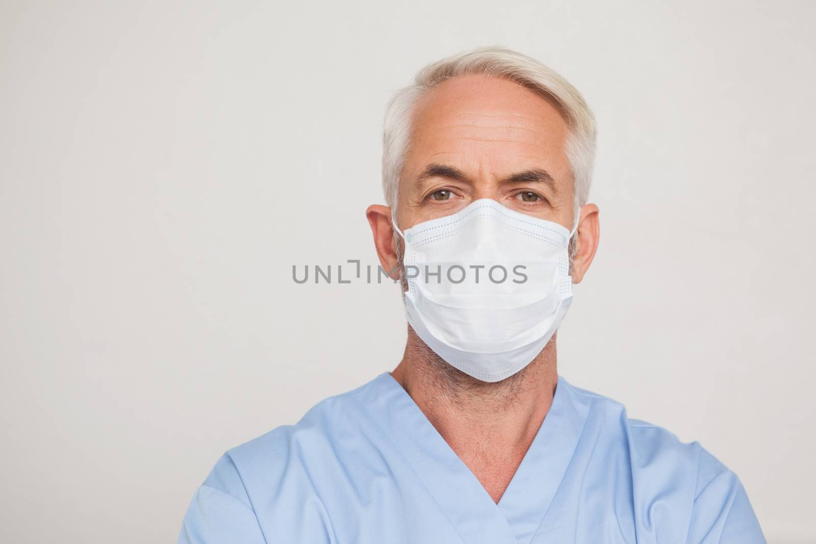 Dentist in surgical mask looking at camera by Wavebreakmedia