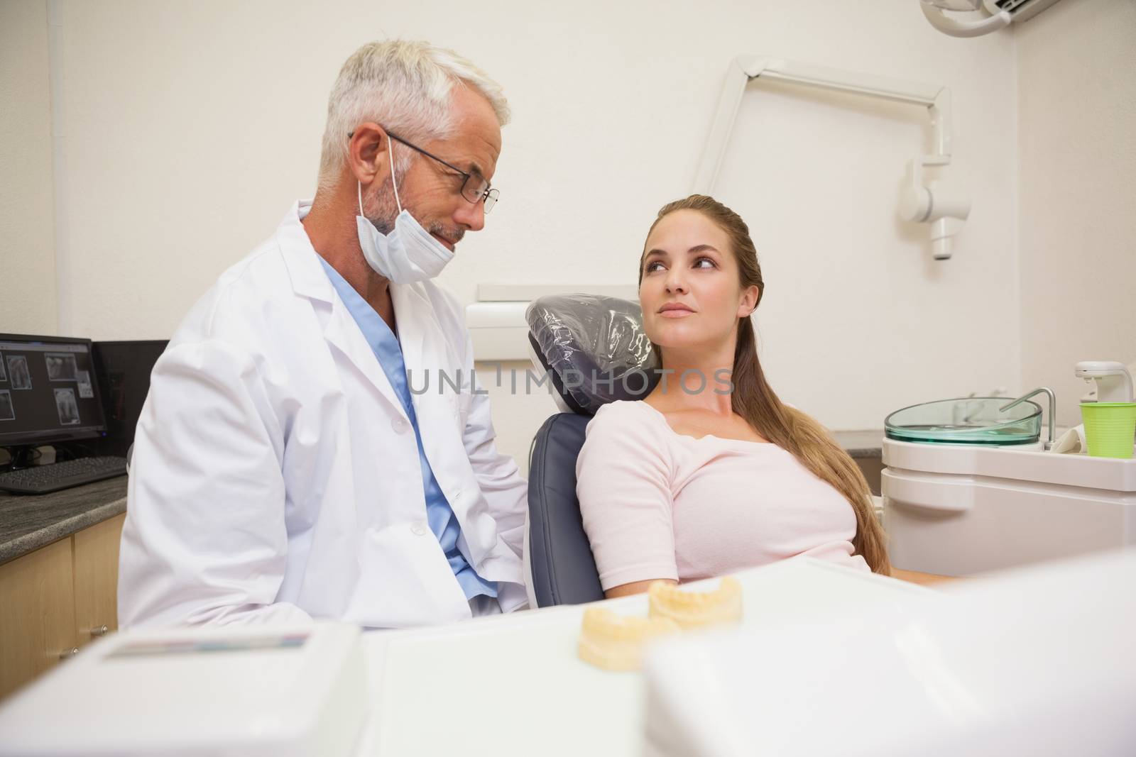 Dentist and patient looking at each other at the dental clinic