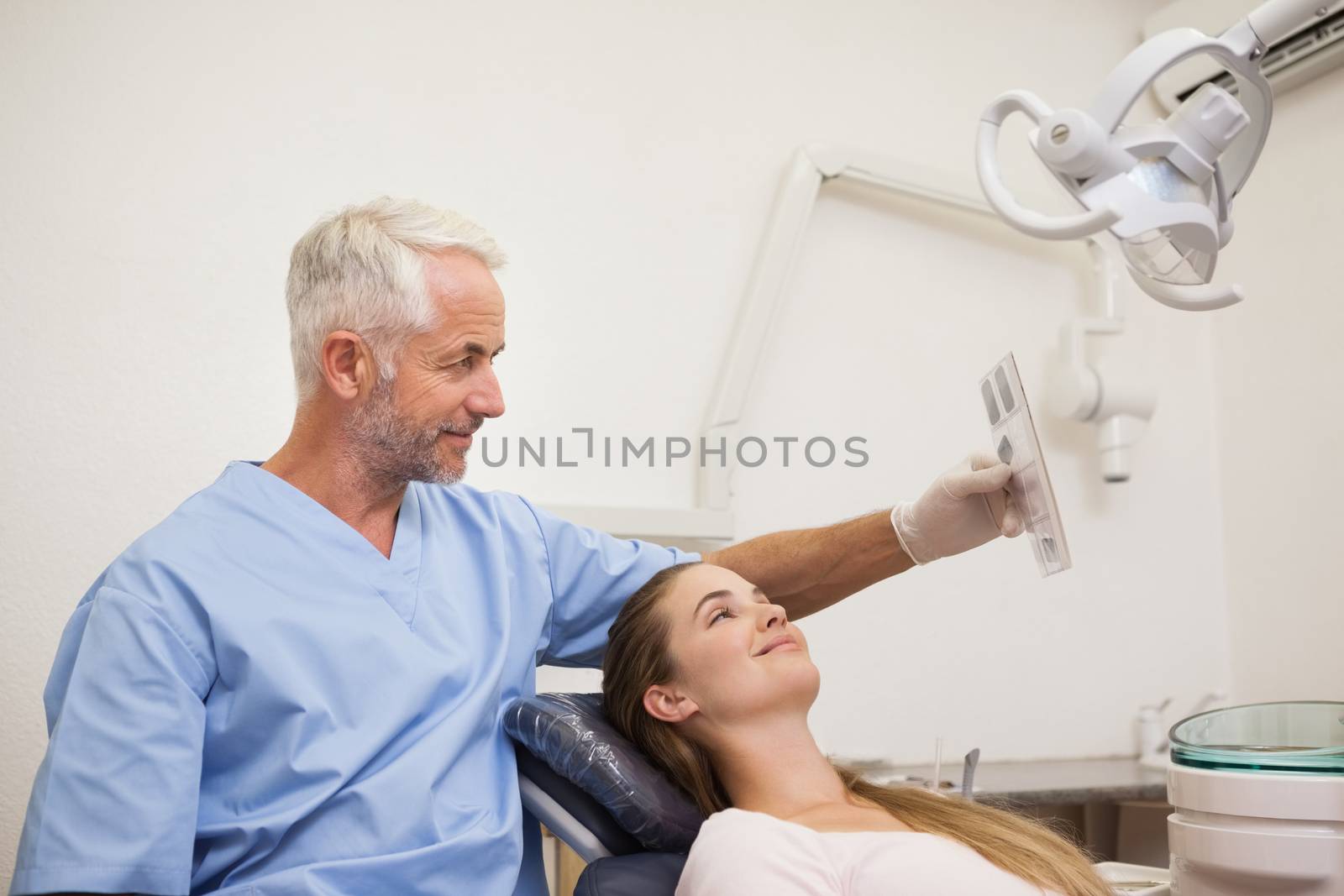 Dentist showing patient her xrays at the dental clinic