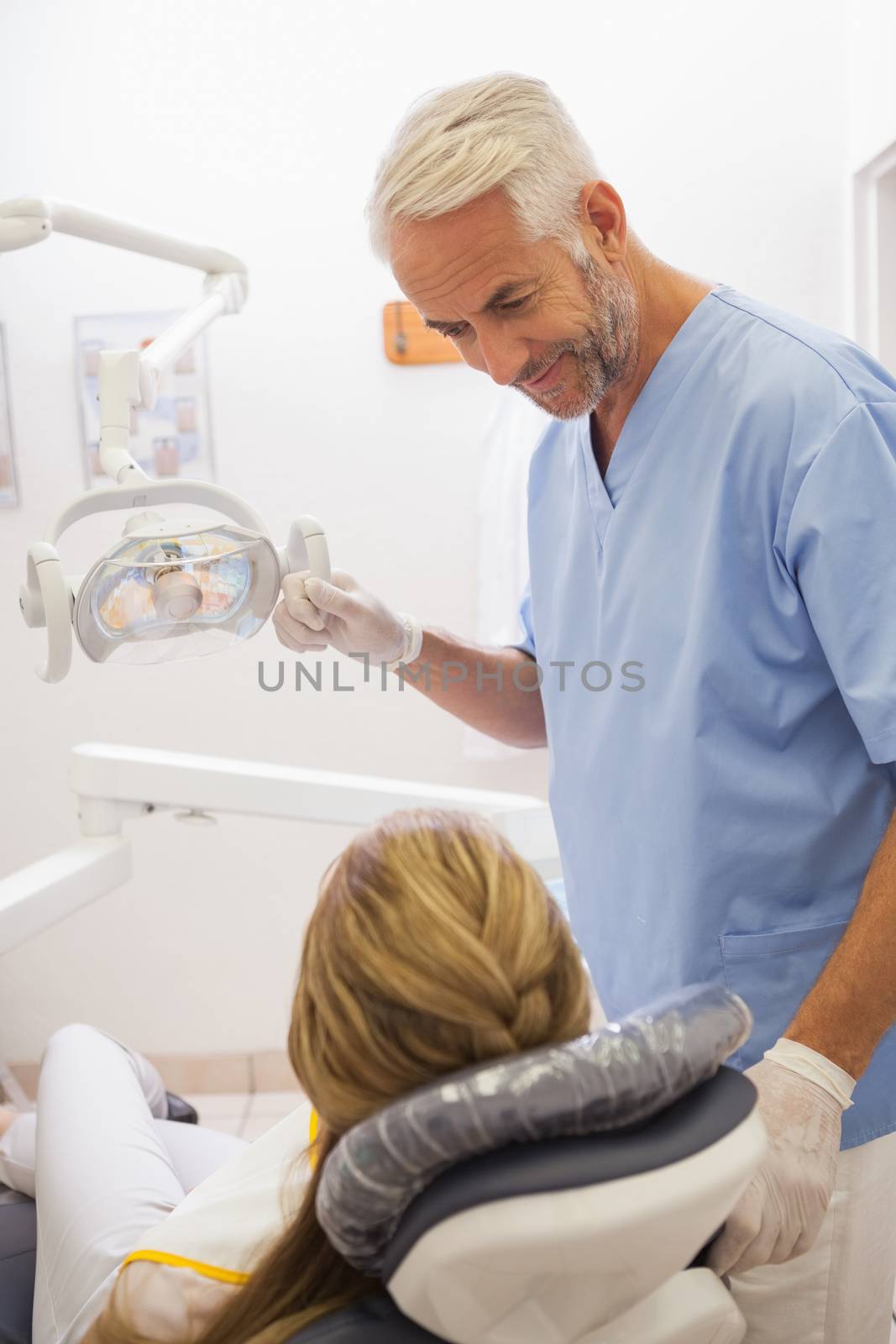 Dentist smiling at patient in the chair by Wavebreakmedia