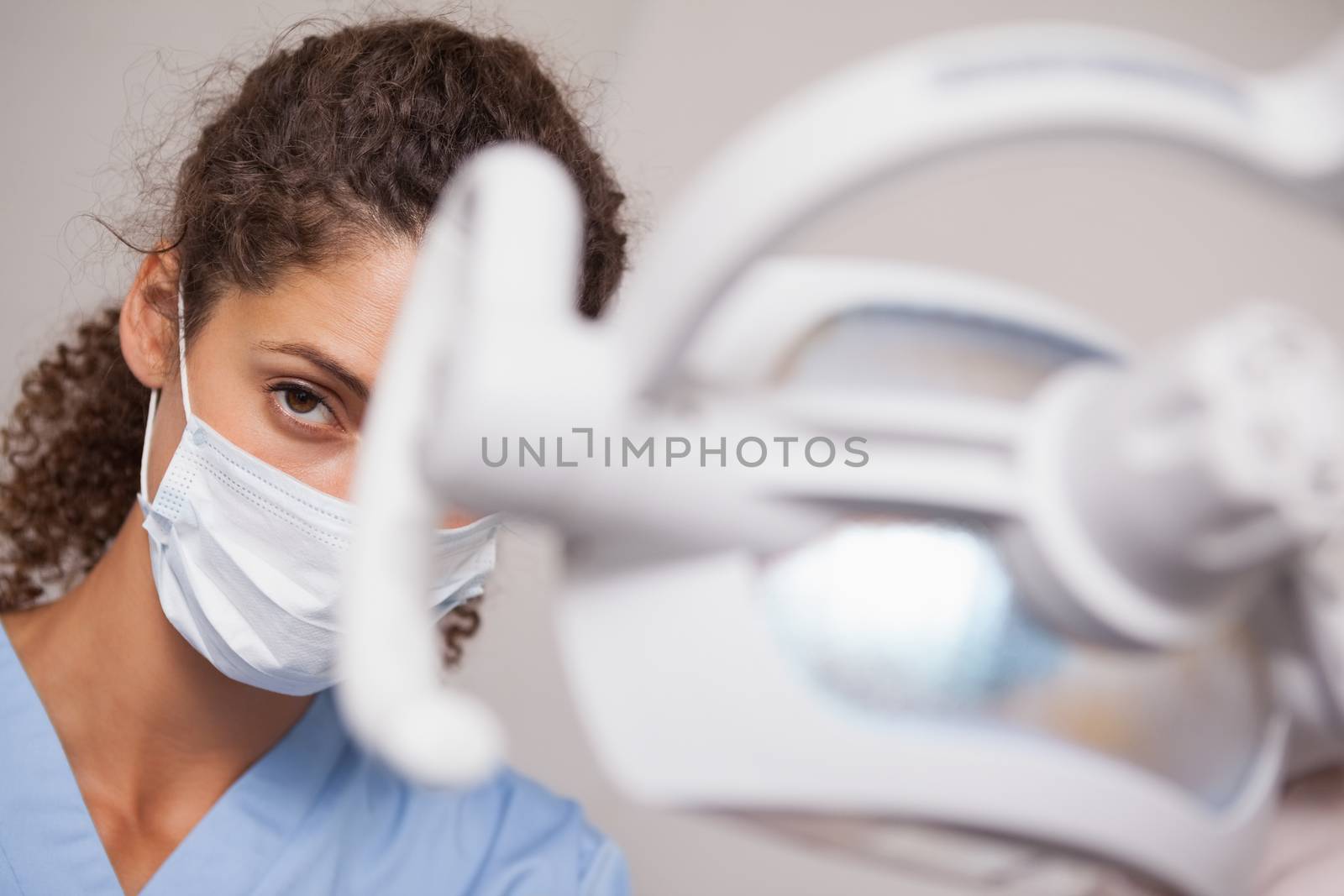 Dentist in surgical mask looking at camera at the dental clinic