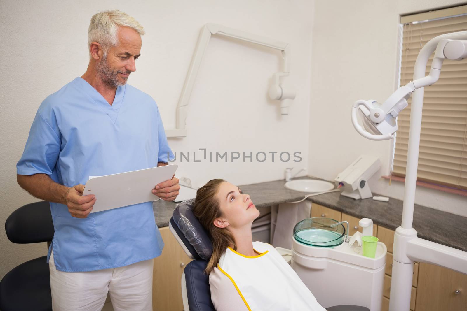 Dentist standing over patient in the chair at the dental clinic