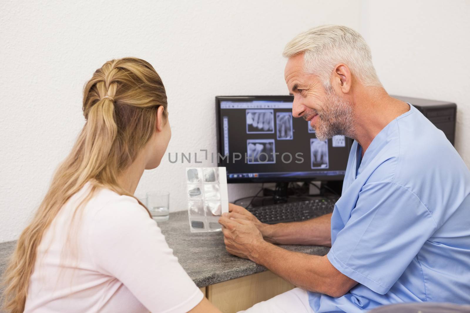 Dentist showing patient her xrays at the dental clinic