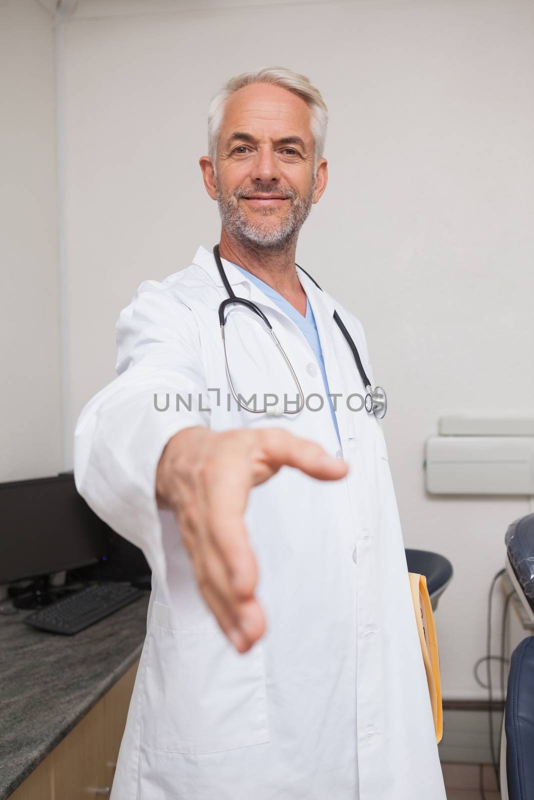 Dentist offering hand to camera at the dental clinic